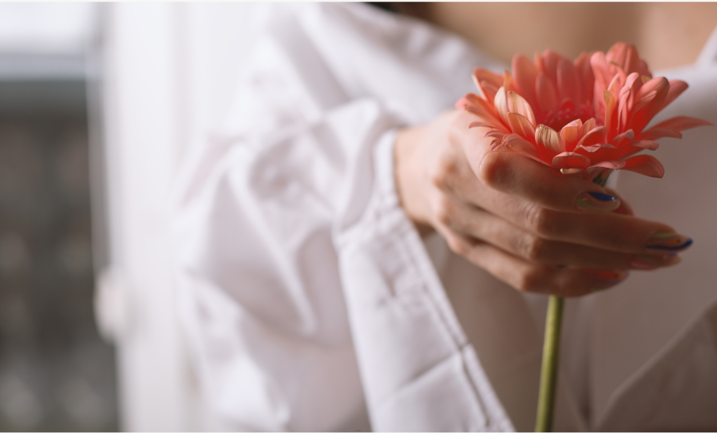 Woman holding a flower symbolising women’s health, balance and wellbeing, promoted by Phoenix Women’s Health.